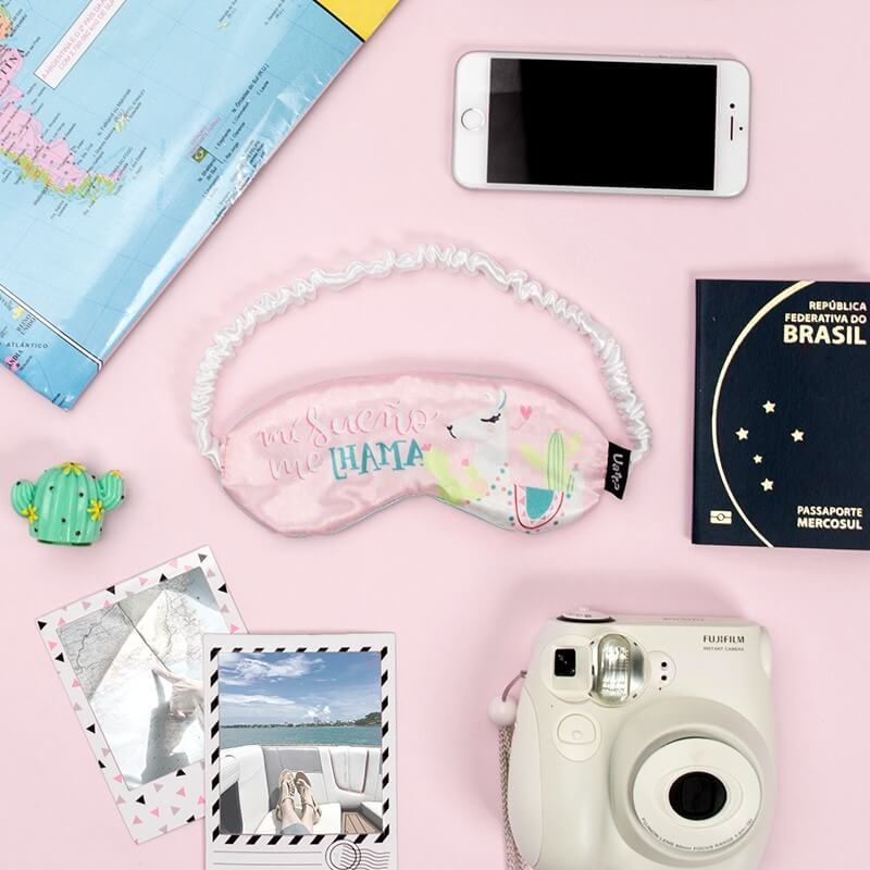 Mapa, celular, instax, passaporte, fotos e máscara de dormir.