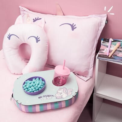 cama cor de rosa com travesseiro, almofada de pescoço e almofada de pipoca.