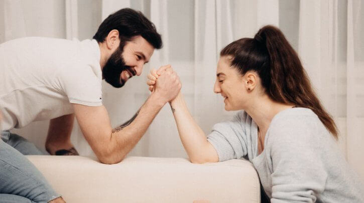 casal disputando queda de braço em uma das brincadeiras para namorados