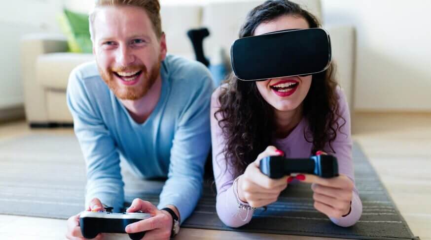 um homem à esquerda e uma mulher à direita com controles remotos nas mãos jogando jogos virtuais