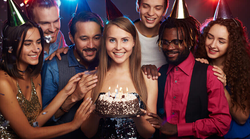 pessoas reunidas ao redor de um bolo e da aniversariante da festa
