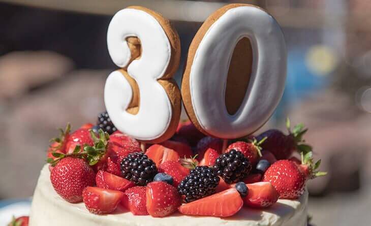 bolo de aniversário com frutas e vela de trinta anos no topo